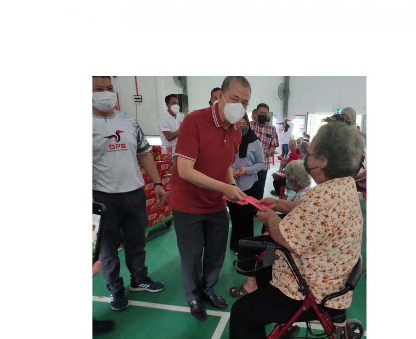工程部长拿督斯里法迪拉尤索派发红包时摄。左为人联党杜邦支部代主席李燕辉。