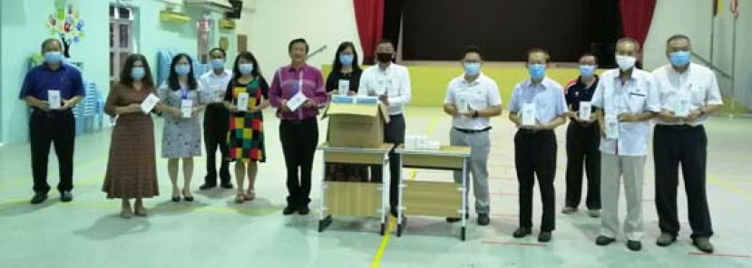 古晋活力团队队长郑志国（右五）移交口罩及温度测量仪予古晋中中校董会主席拿督黄良杰（右六），右八为古晋中华小学校董会主席拿督王长福。