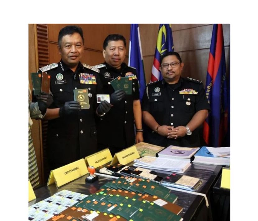 移民局总监扎卡利雅(左一)展示所起获的各国护照等。