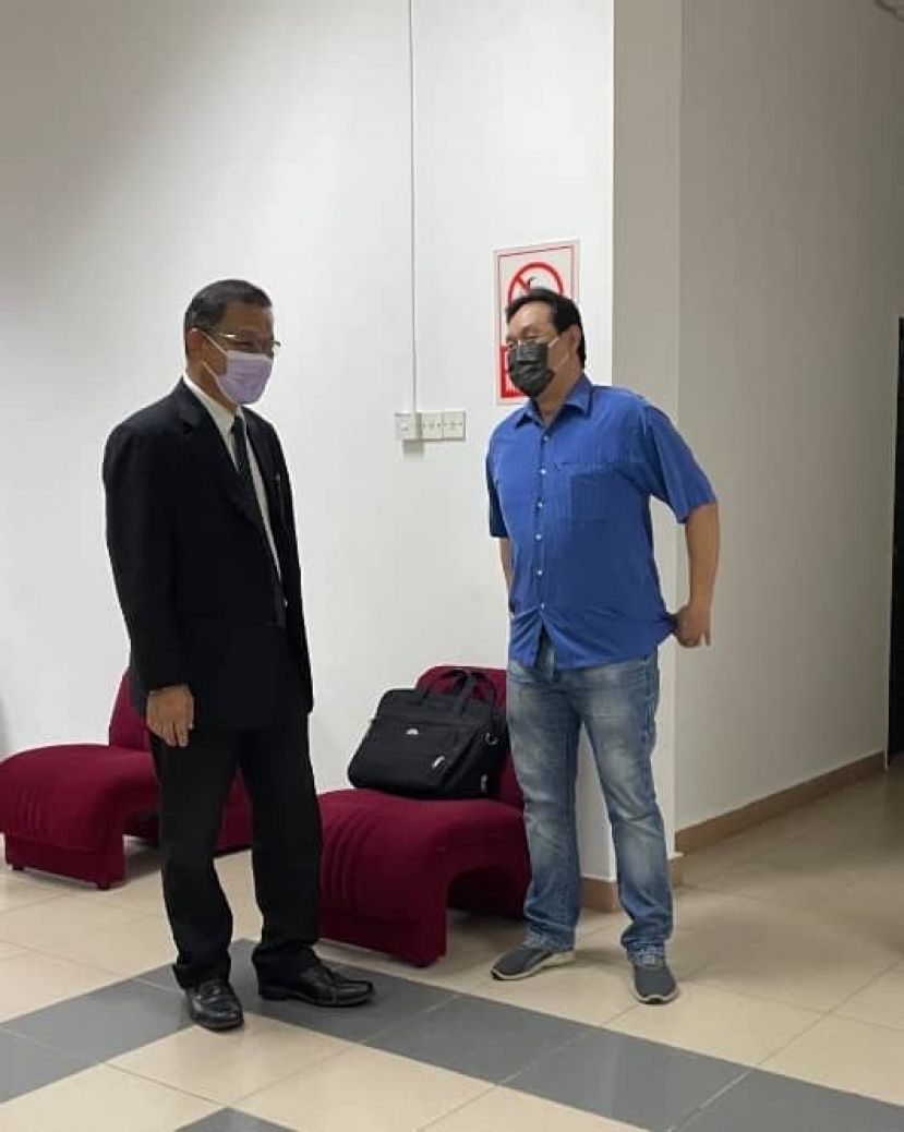 因技术问题而脱罪的男子和辩护律师交谈时摄。