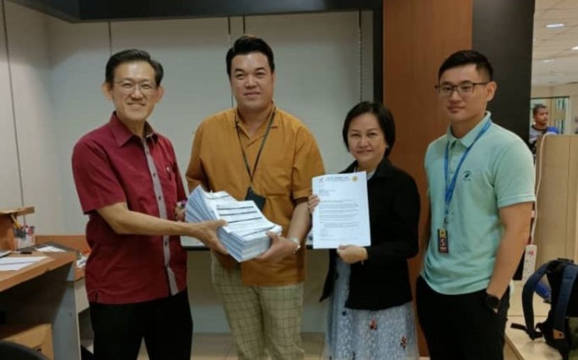 薛华东（左1起）将助写的群众申请爱心援助金表格移交官员沙弥南；右起是官员艾伦、人联峇都林当支部执行秘书郭小凤。