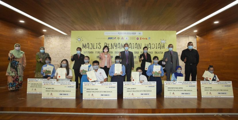 颁奖者与得奖学生合影，颁奖者包括吉隆坡市政府计划管理执行长哈斯玛（后排左二）、国家语文局语文及文学发展部哈扎米博士（后  排左三）、驻马来西亚台北经济文化办事处代表洪慧珠 （后排左四）、马来西亚汉文化中心拿督吴恒灿（后排右四）、国家文化与艺术局副局  长阿姆蓝（后排右二）、原住民发展局代表苏海米（后排右一）。  