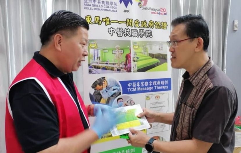 薛华东（右）与砂医总会长江宗兴（左）在为民众提供社险福利觉醒咨询活动中交流。