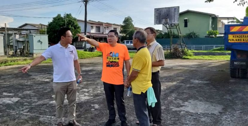 古晋市长拿督黄鸿圣（左二）在符祥威陪用下巡视环绕河景园四周住宅区的沟渠。