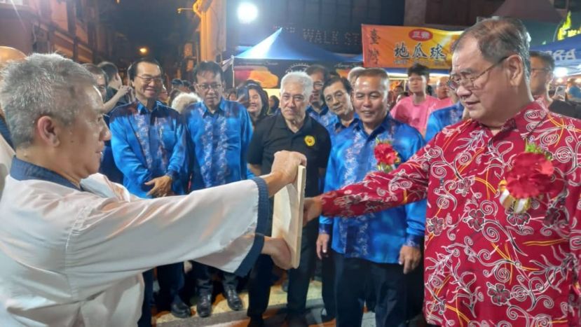  古晋省民众联谊团体总会会长郑文新（右起）在庆典大会会长甲必丹林传政等人陪同下，在砂唐手道协会表演现场也表演拳击木板功夫。