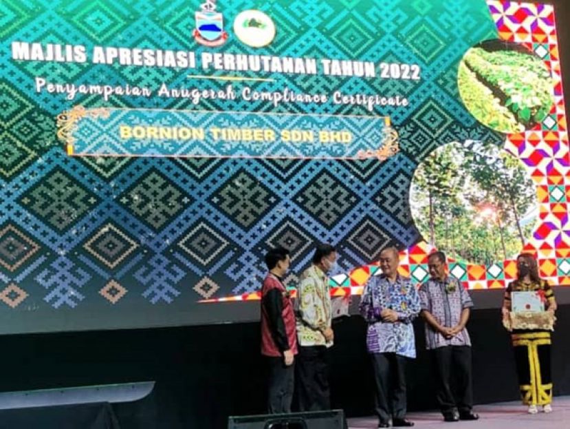 沙巴首席部长拿督斯里哈芝芝（右三）颁奖给沙巴婆联木业代表胡凤城。