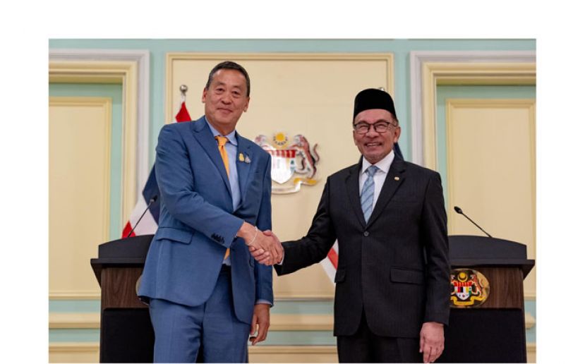 首相安华(右)与到访的泰国首相赛塔(左)握手。