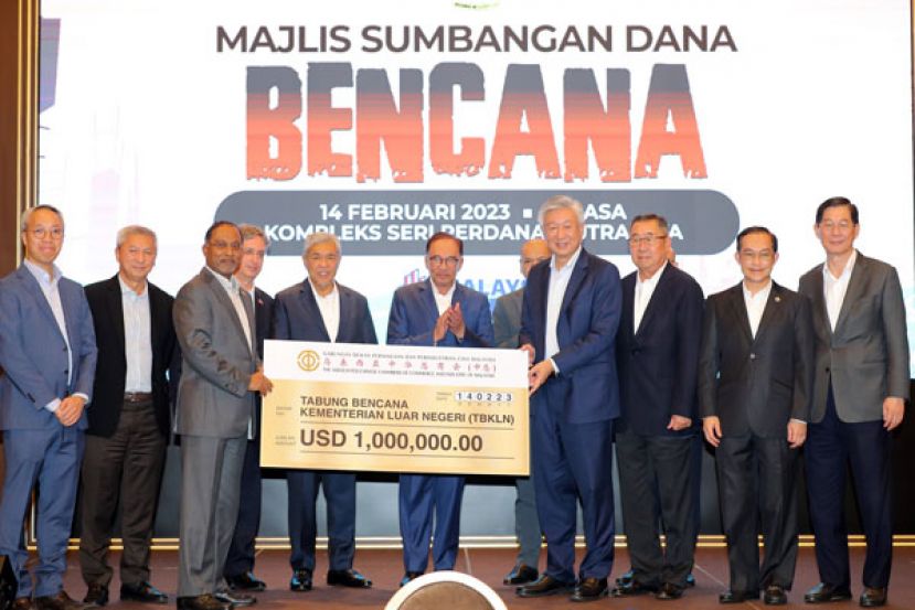 丹斯里卢成全（右四）在拿督斯里安华（中）与拿督斯里阿末扎希（左五）见证下，移交100万美元模拟支票  予赞比里（左三）；左起是谢立凯与管保强，右起是丹斯里林宽城、拿督李耀祖及丹斯里李爱贤。