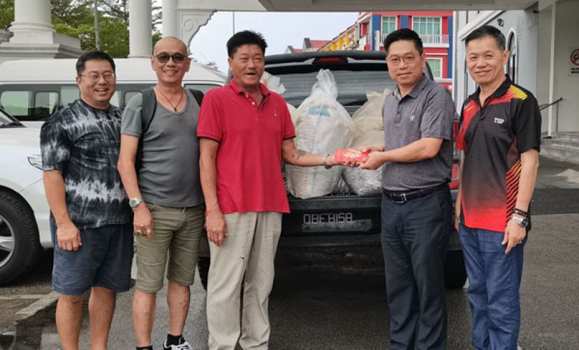 紫辉阁阁长蔡岷谷（右二）自蘧经汉（左三）接受一万令吉及60公斤拉环。右一为总务彭国良，在一为青年团副团长蔡燕城及董委蔡传武。