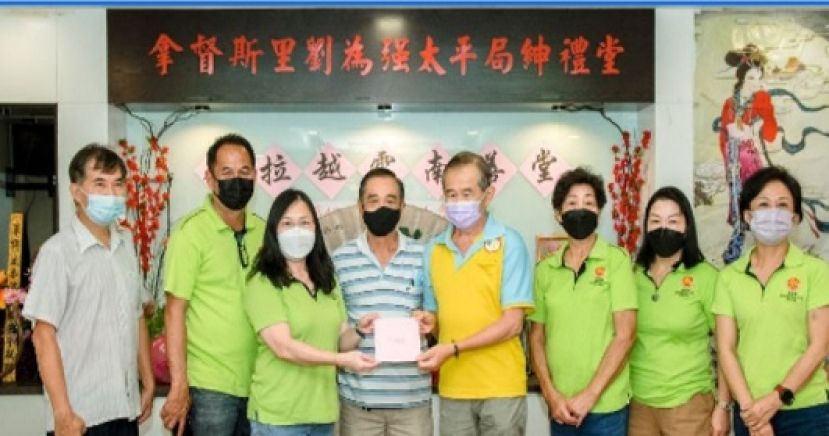 云南善堂的秘书长张南华先生移交感谢卡给邓氏公会妇女组主任邓群娇。