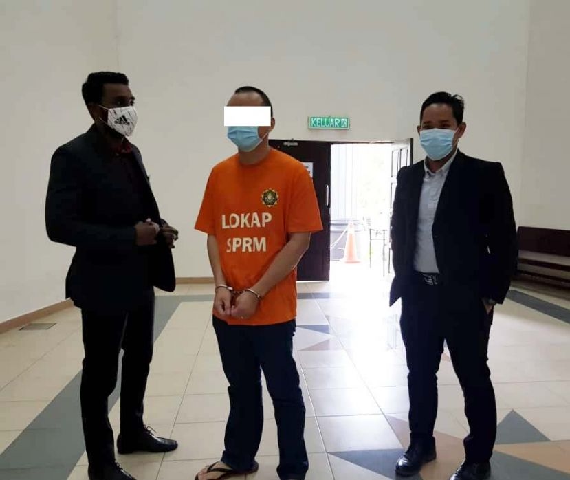 涉嫌以1万8500令吉贿赂警员的嫌犯等候过堂时摄。