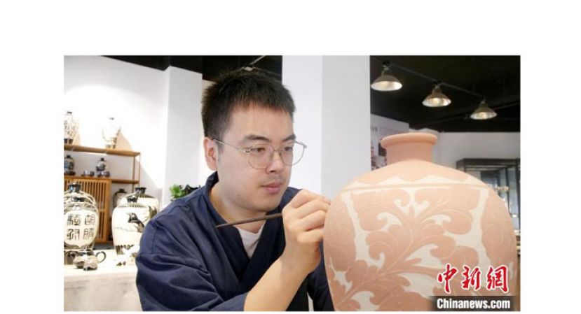 赵英杰在磁县磁州窑工作室内为陶瓷进行剔花作业。