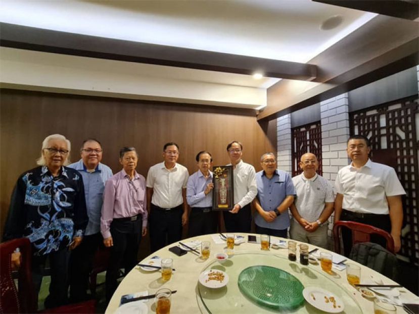 古晋漳泉公会会长郑佑上（左五）移交纪念品给泉州市人民政府副秘书长张劲竹（右四）。左一起为古晋漳泉公会会第三任会长暨厦门海外联谊会顾问谢扬信、古晋漳泉公会会署理会长拿督黄国辉、砂拉越中华总商会会长拿督陈日枝、中国驻古晋总领事邢伟平、古晋漳泉公会会长郑佑上。右一起为泉州市文化广电和旅游局副局长周梁升、古晋漳泉公会会创会会长黄武耀、 古晋南市长拿督黄鸿圣。