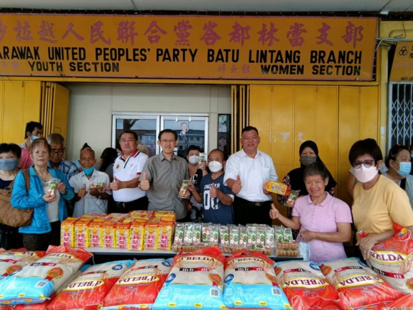 薛华东（前排左5）联袂甲必丹陈庆耀（左4）、陈中兴（左7）、蔡秋花（右1）在人联党峇都林当支部前移交布施食品予感恩户。