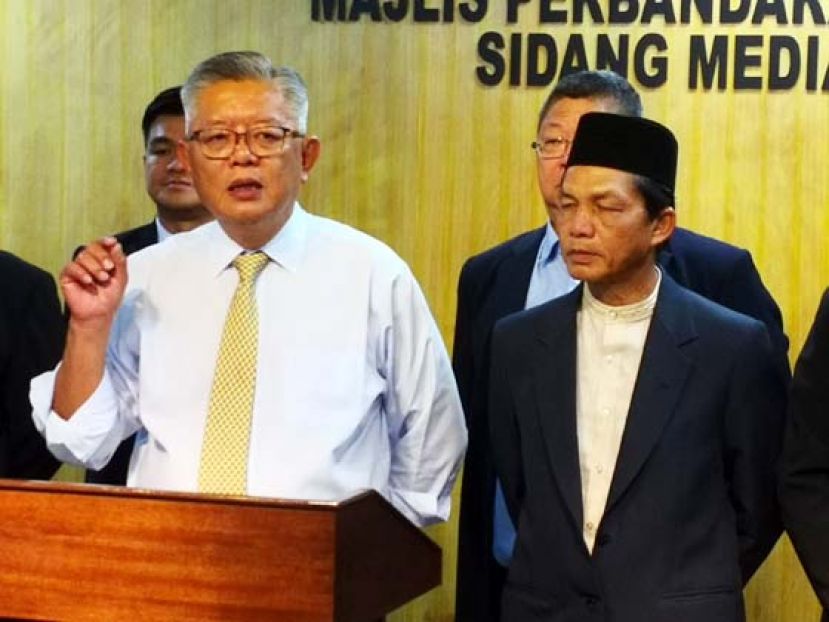 诗巫市议会主席丁永豪（左）向媒体发言。