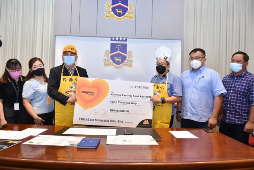 Magnum 4d东马区域营运经理刘其全（左三）移交赞助模拟支票予古晋南市市长拿督黄鸿圣（右三  ），右二为2022年古晋美食节筹委会主席吴芝辉市议员。