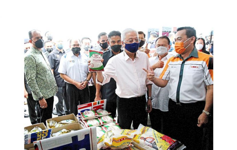 首相依斯迈沙比里周四在班底达南大马一家销售计划活动上了解物品价格。