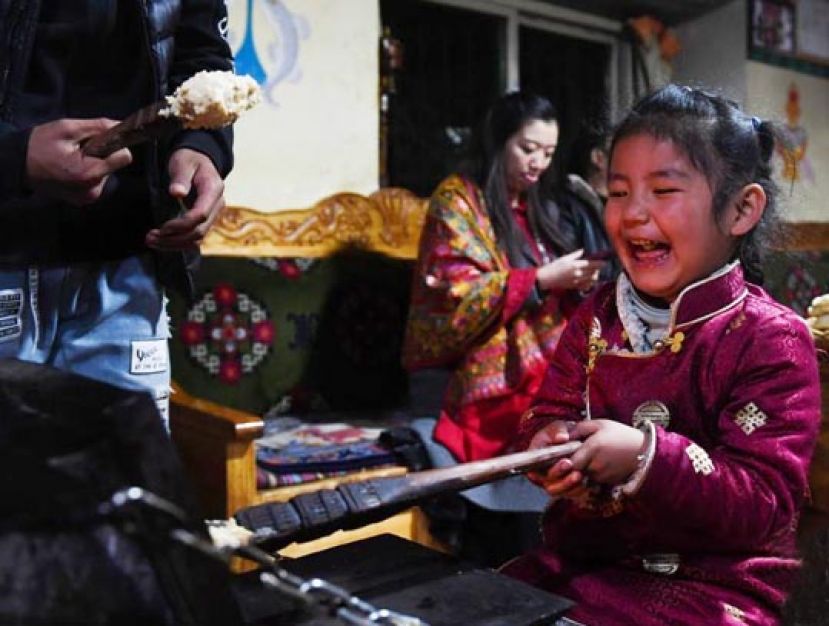 图示：11月7日晚，工布新年除夕之夜，林芝市扎西岗村巴桑一家人按照习俗聚在一起，吃&ldquo;结达&rdquo;（&ldquo;结达&rdquo;由酥油、牛奶、糌粑和白糖揉成，用炉火加热之后食用），迎接工布新年。 