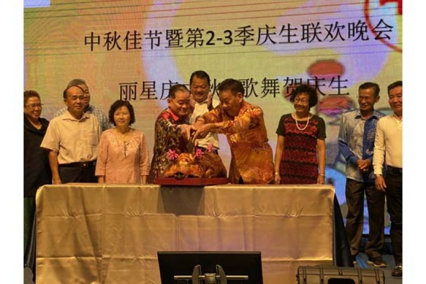 古晋丽星文娱协会永久名誉会长拿督斯里刘为强（前排左四）和永久名誉会长黄启萍（右四）在贵宾们陪同下共切烧猪，为晚宴开幕。