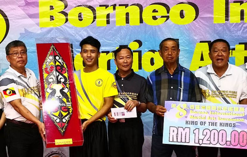 砂拉越龙狮武术总会(左一）颁奖给勇夺《王中王至尊奖》的许维柏。右一是诗巫拳术健身协会与砂拉越陈式太极拳协会会长熊洺丰。