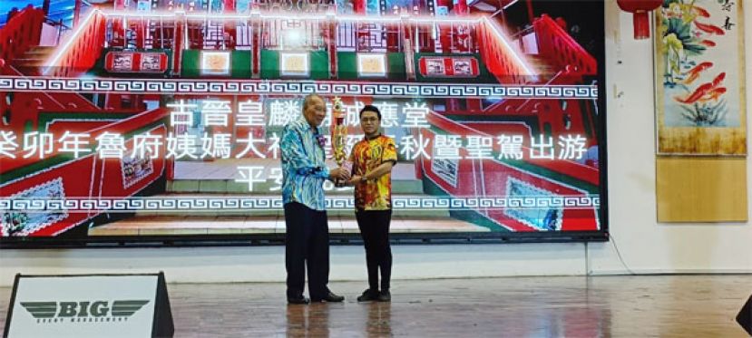 古晋皇麟庙诚应堂大会主席郑顺安（左）颁发狮队组冠军砂拉越予新洋体育会代表。