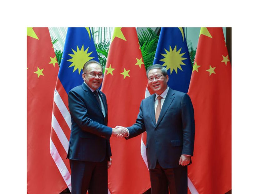 首相拿督斯里安华(左)与中国总理李强亲切握手。