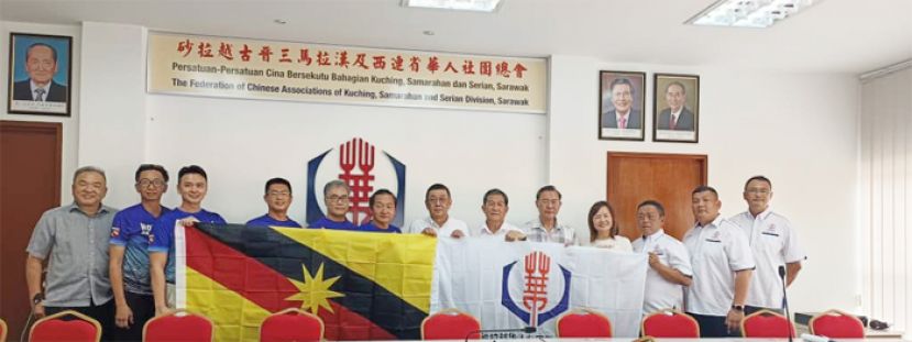 砂华总会长拿督黄良杰（右七）移交砂拉越旗帜及华总旗帜予龙舟赛队伍的代表。左起为晋汉连省华总副总协调何晋兴、龙舟队队员周强、龙舟队队员蔡佑伦、龙舟队领队林吴鸿任、队员蔡卓维、教练李国豪；右起为晋汉连省华青团第一副团长甲必丹陈俊贤、华青团署理团长陈小文、晋汉连省华青团团长甲必丹陈德明、晋汉省妇女组主任张慧娇、晋汉连省华总副会长张光福及晋汉连省华总秘书长林亚德。