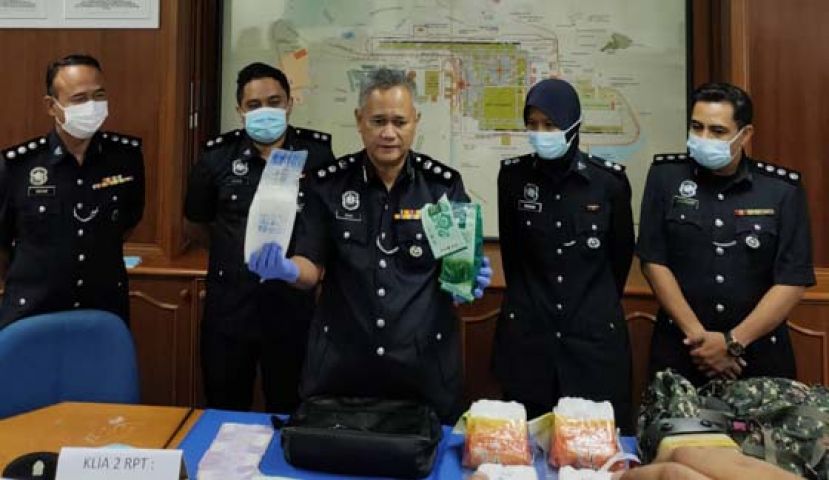 英兰助理总监（中）展示行动中起获的毒品。