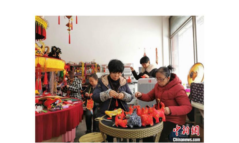 虎年春节将近，61岁的民间手工艺人马改莲和其他手艺人们围着针线簸箩，赶制布老虎。