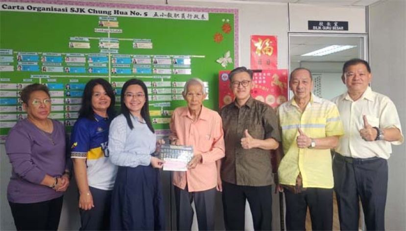 方由传（右4）在薛华东（右3）见证，移交其研发的&ldquo;方氏数字转轮算盘&rdquo;及捐献五小欲建礼堂一千令吉予五小校长郑茗月（左3）。左起为该校校友会财政朱缮霖，课外主任温惠妮，右起是陈中兴、孙守生。