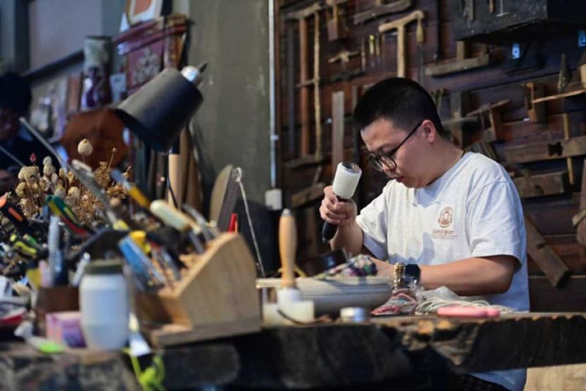 在伊犁老城，曹红兵正在制作皮具。