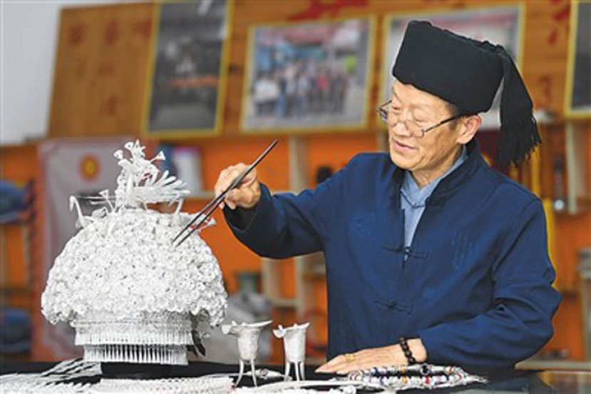 杨正贵在制作苗族银帽。