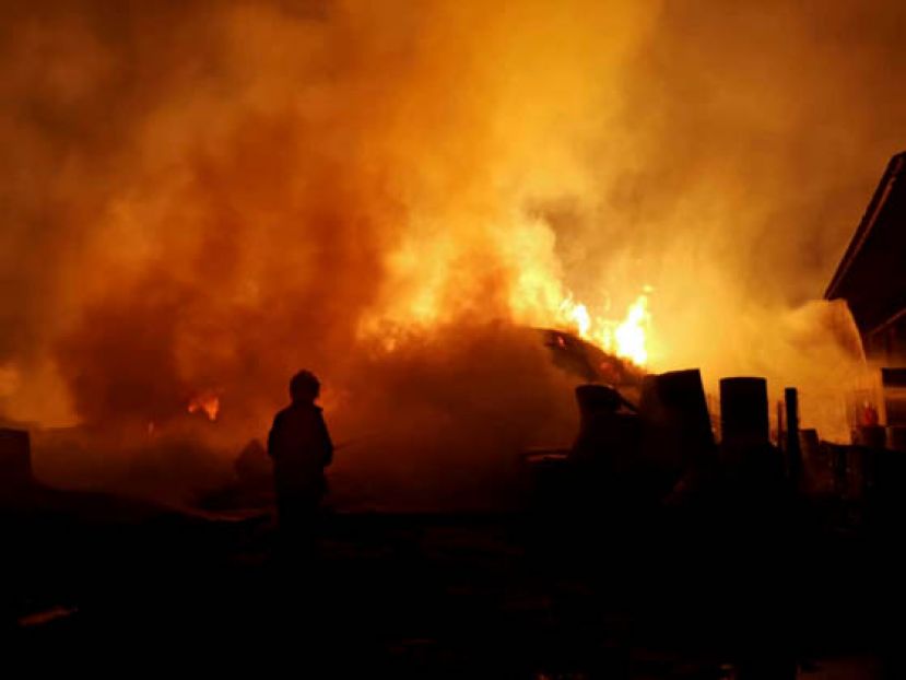 消防员向冲天火焰喷水。