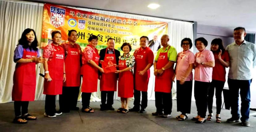 在福州美食烹饪示范会上，总会长夫人拿汀斯里黄赛芳（左六）获赠纪念品，左五为拿督斯里刘为强太平局绅。
