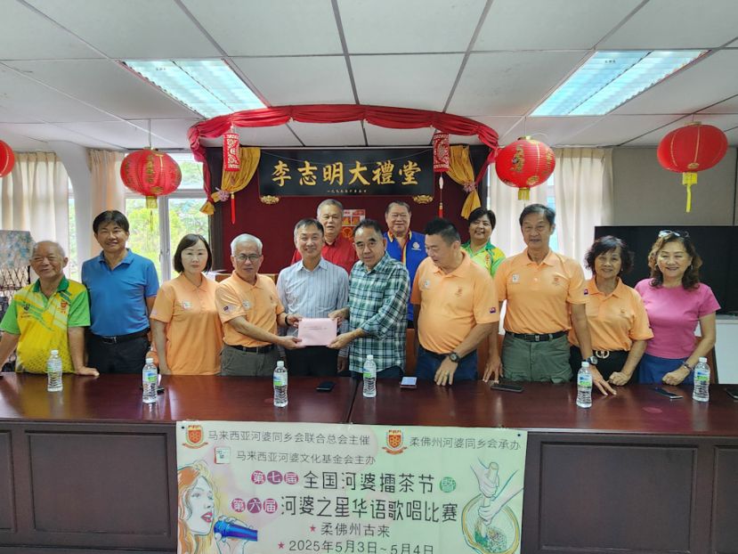 2025年全国河婆擂茶节暨河婆之星华语歌唱比赛筹委会大会主席吴国文（左4）在马来西亚河婆同乡会联合总会永久名誉总会长张添堡（左5）的见证下，移交2025年全国河婆擂茶节暨河婆之星华语歌唱比赛邀请函给砂拉越河婆同乡会署理主席天猛公刘石星（右5）。 前排左起为砂拉越河婆同乡会乐龄主任蔡树海、砂河婆同乡会秘书长巫虎财、擂茶节筹委会歌唱比赛主任刘秋萍、擂茶节筹委会秘书吴国潭、擂茶节筹委会财政刘志华、擂茶节筹委会主席李菜花、砂拉越河婆同乡会理事吴雪莲。后排左起砂拉越河婆同乡会副秘书长蔡易沩、文教主任邓景文及副资讯李素慧。