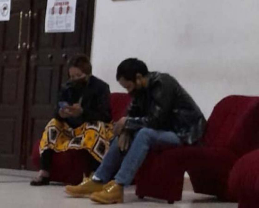 保姆夫妇在庭外等候开庭时摄。