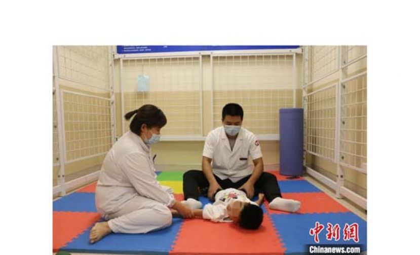 刘霞（左）给患者做康复训练。