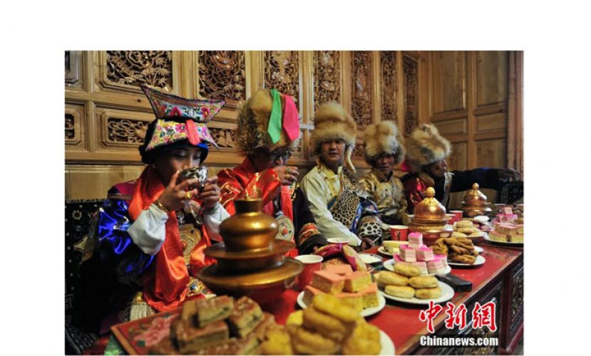 2016年3月，云南迪庆藏族自治州，民众与家人坐在一起喝酥油茶聊天。