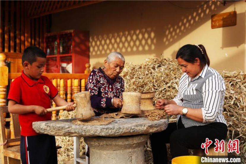 桑皮纸制作人加工桑树皮。