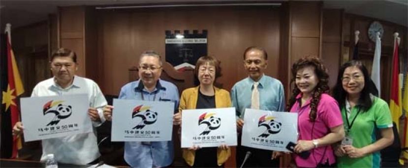 古晋南市市长拿督黄鸿圣（左二）、中国驻古晋副总领事宋长虹（左三）、古晋福州公会主席拿督余志豪（右三）以及古晋福州公会妇女组主任刘碧云等在展示马中建交50周年海报时影。
