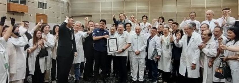 古晋南市市长从杨重振（左）从《马来西亚纪录大全》职员化里斯胡仙接跟证书时影。