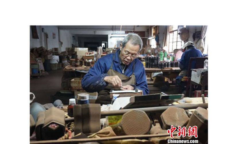 无锡梅村一家二胡工坊中，老手艺人正在打磨制作二胡的零部件。