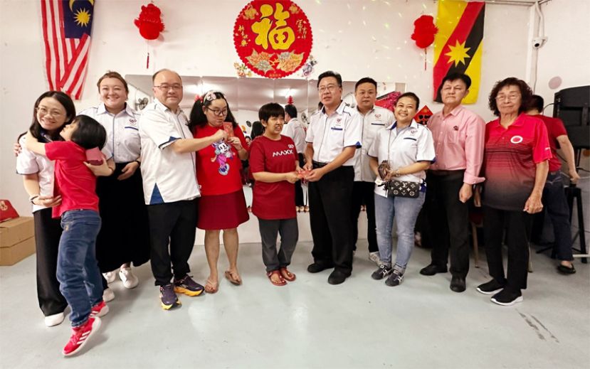 善心组织副会长甲必丹拿督刘思乐（左4）、理事田志和（右5）与义工刘亿（左1）派发红包予孩童时影。左3为义工蔡凌、右1起为砂拉越特殊儿童家长协会创会会长郑新香、财政张衡祥、义工郭燕珠、文朝龙。