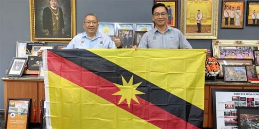 古晋南市市长拿督黄鸿（左）授旗予黄锡平时影，祝愿他参赛取得胜利。