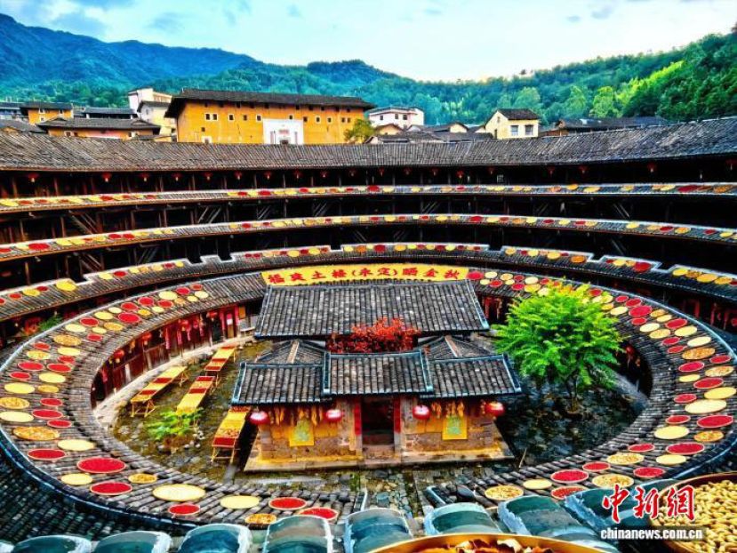 在永定初溪土楼群的集庆楼内，数十个木质晒架整齐排列，当地村民正忙着将刚收获的农作物晾晒其上。