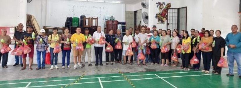 古晋南市市长拿督黄鸿圣（左九）送上生活物资，和受惠群体合影。