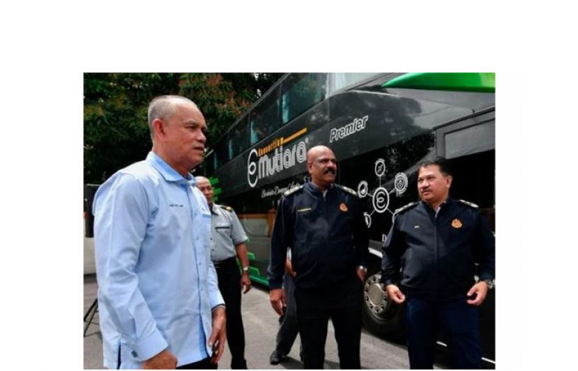 陆交局副总监加纳卡拉占(左)查看长途巴士。