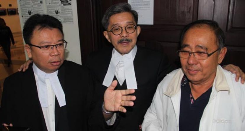 林咸慈的父亲（右）在女儿获得无罪释放后和两名辩护律师在庭外合影。