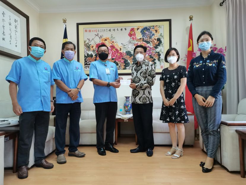 中国驻古晋总领馆程广中总领事（右三）移交防疫捐款予砂拉越华人社团联合总会会长拿督黄良杰（左三）。