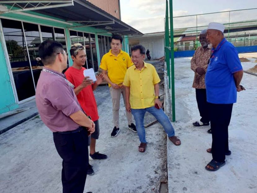 拿督沈桂贤（右三）向承包商了解石角徙置区民众会堂足球场提升工程的进度。